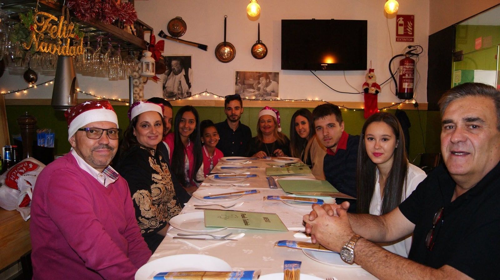 Una cena de Navidad de grupo en el comedor, con cazuelas de cobre en la pared