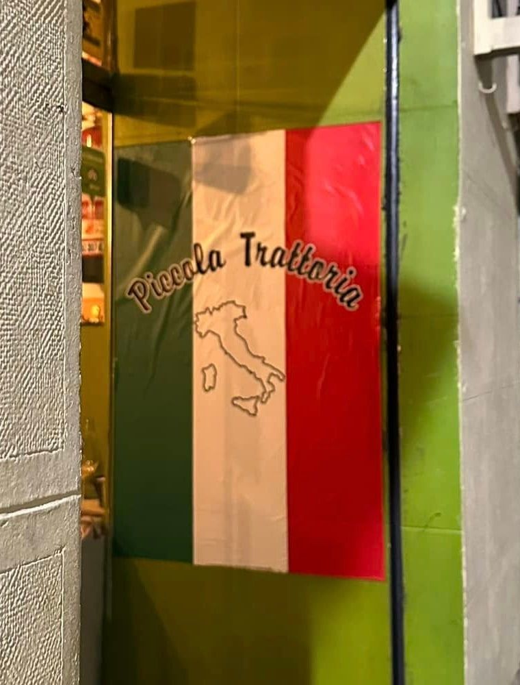 El cartel pintado 'Piccola Trattoria' con los colores de Italia